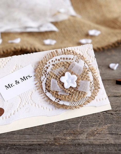 Shabby chic wedding invitation on old wooden table. Vintage wedding card you can create yourself. Idea for wedding invitation decor. Closeup