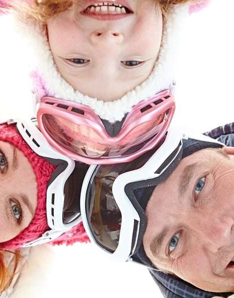 Directly below shot of positive family wearing ski goggles