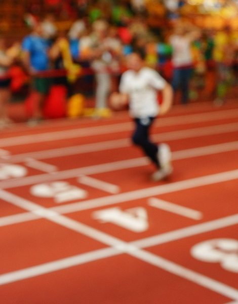 Blurred image of children athletes on a racetrack during finishing. Participants of the race finish in the race. The background image, an abstraction.