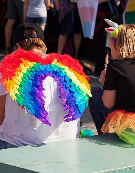SOUTHAMPTON UK - August 26 2017: Southampton Pride 2017 City's second annual Pride event in Southampton UK. Mother wearing rainbow fairy wings sitting with daughter wearing a rainbow skirt. Rainbows symbolizing Pride.