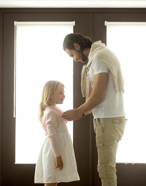 Caring dad gets daughter ready for school or walk standing at entrance door home hall, loving father buttoning cute girl, daddys little princess, spending time with kids, being good parent concept