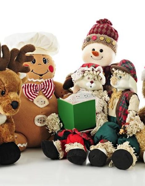A collection of stuffed Christmas critters surrounding Ma Bunny who holds a Christmas carol book (or storybook) for the others to enjoy.  On a white background.