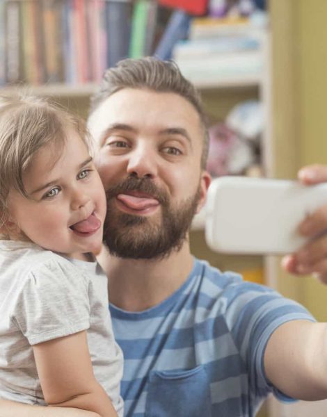 Young father with his cute little daughter taking selfie