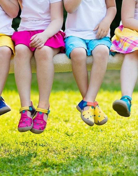 Footwear for children. Group of preschool kids wearing colorful leather shoes. Sandal summer shoe for young child and baby. Preschooler playing outdoor. Child clothing foot wear and fashion.