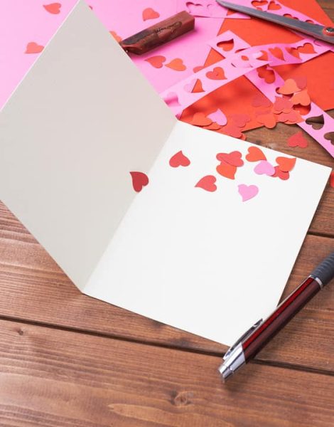 Making valentine card and confetti composition over the wooden surface as a copyspace card template