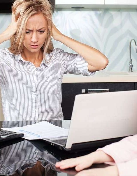 Sad woman looks at the bill. Female working at home. Child Makes moms work
