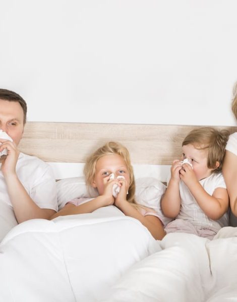 Sick Family Lying In Bed At Home